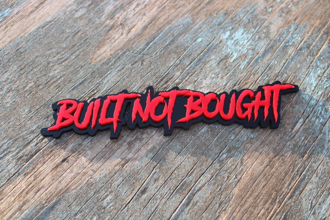 Badge de voiture « Built Not Bought » - Rouge sur noir brillant - Police agressive