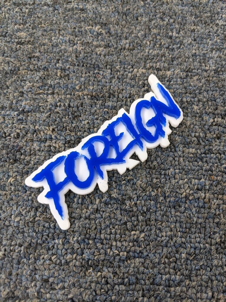 Foreign Car Badge - Blue on White - Aggressive Font - Tape Mounting - Atomic Car Concepts