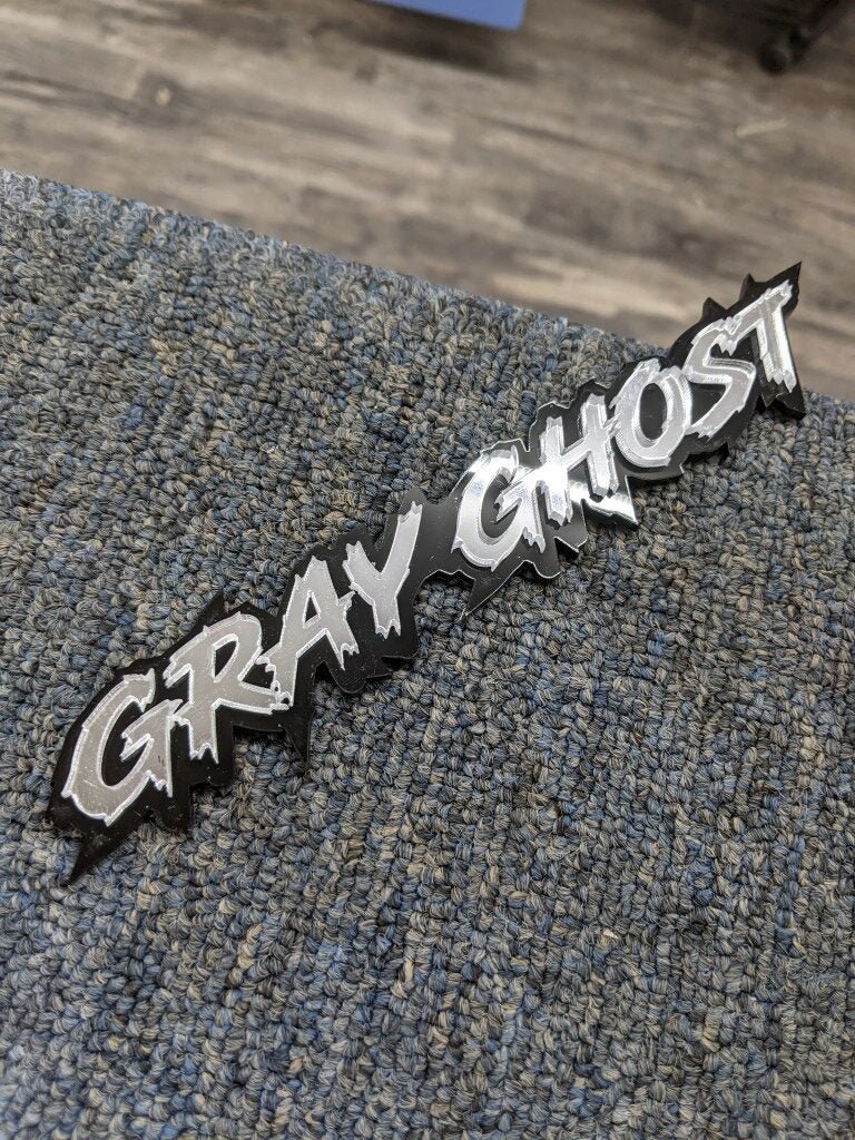 Gray Ghost Car Badge - Mirror Silver On Gloss Black - Lightning Font - Atomic Car Concepts