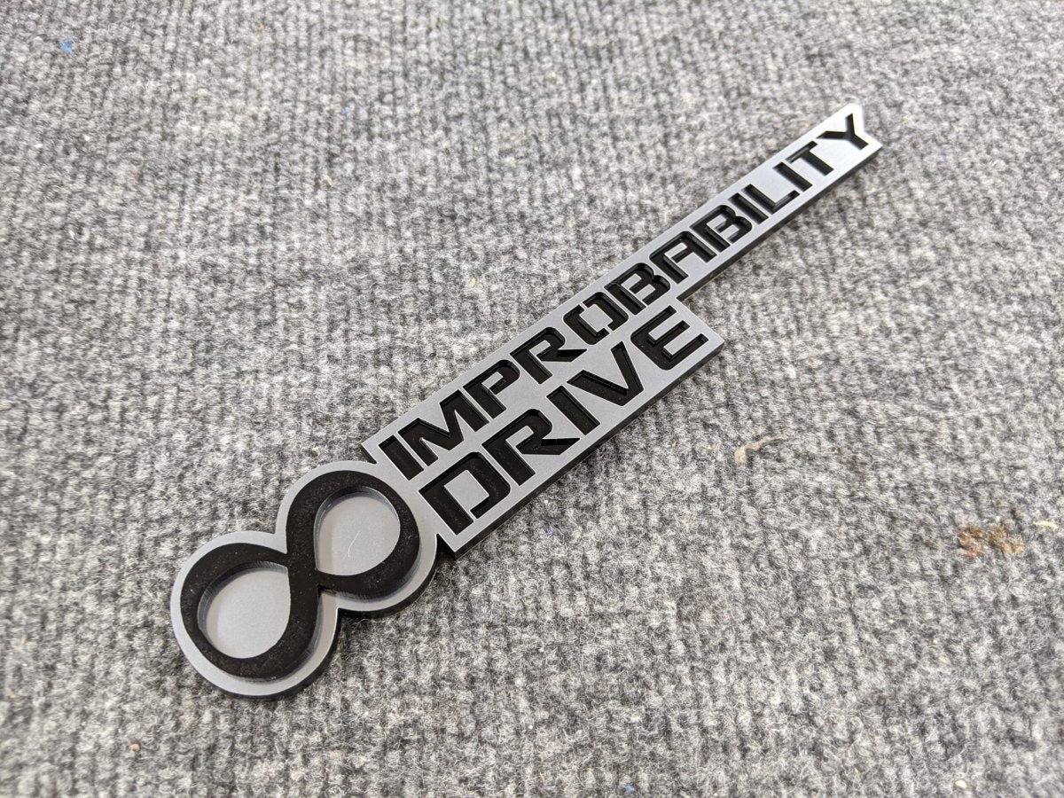 Infinite Improbability Drive Badge - Black and Brushed - Atomic Car Concepts