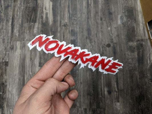 Novakane Car Badge - Red on White - Lightning Font - Tape Mounting - Atomic Car Concepts