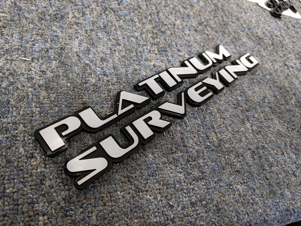 Platinum Surveying Car Badge - Grey on Gloss Black - OEM Font - Tape Mounting - Atomic Car Concepts