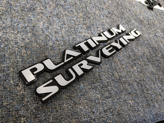 Platinum Surveying Car Badge - Grey on Gloss Black - OEM Font - Tape Mounting - Atomic Car Concepts