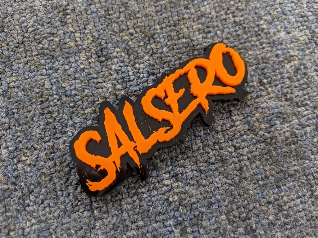 Salsero Car Badge - Orange on Gloss Black - Aggressive Font - Tape Mounting - Atomic Car Concepts