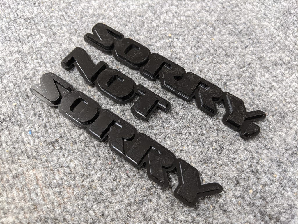 Sorry, Not Sorry Car Badge - Gloss Black On Gloss Black - OEM Font - Atomic Car Concepts