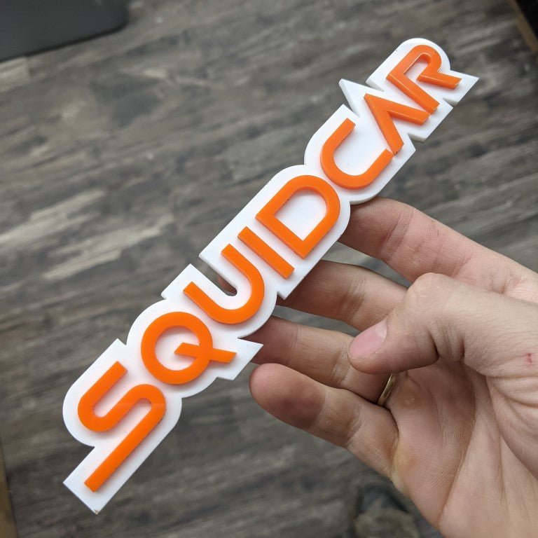 Squidcar Car Badge - Orange On White - Squid Font - Custom Mount - Atomic Car Concepts