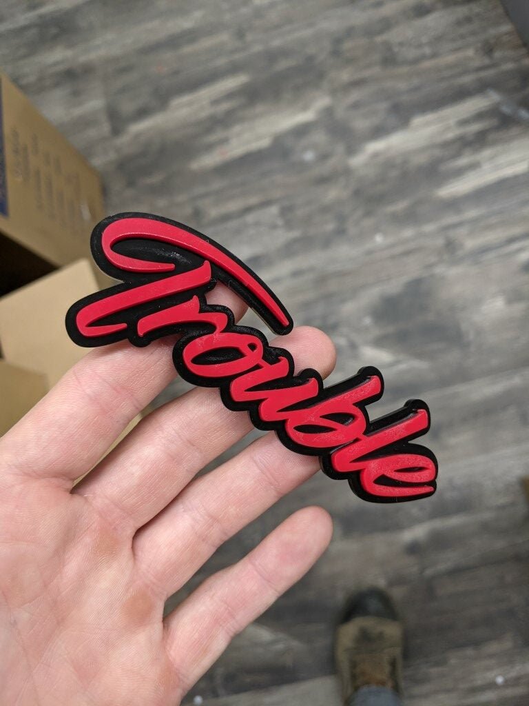 Trouble Car Badge - Red On Gloss Black - Script Font - Atomic Car Concepts