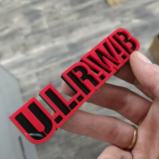 U.L.R.W.B Car Badge - Red On Gloss Black - Stencil Font - Tape Mount - Atomic Car Concepts